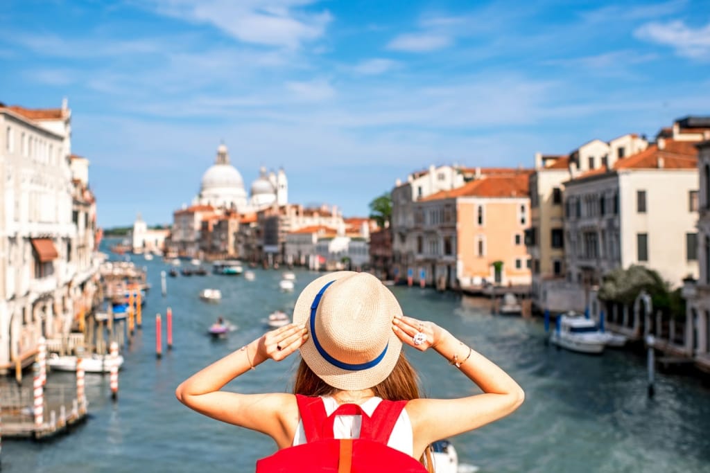 View on Grand canal with woman traveler in hat on Academia bridge in Venice.