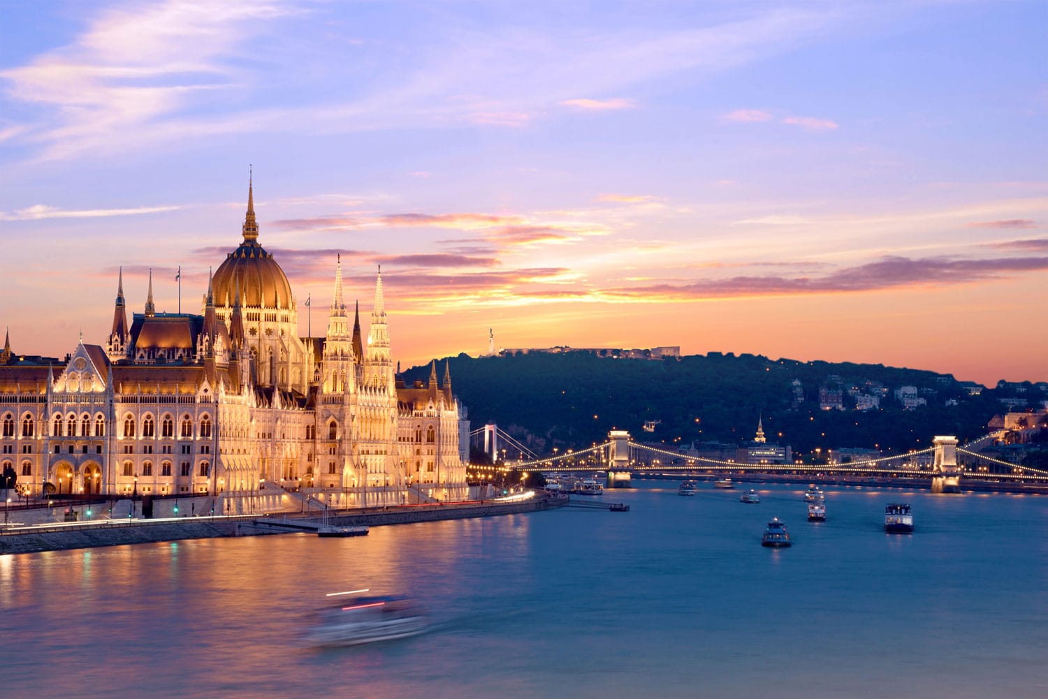 Pemandangan Parlemen yang indah dan jembatan di atas Danube di Budapest saat matahari terbenam