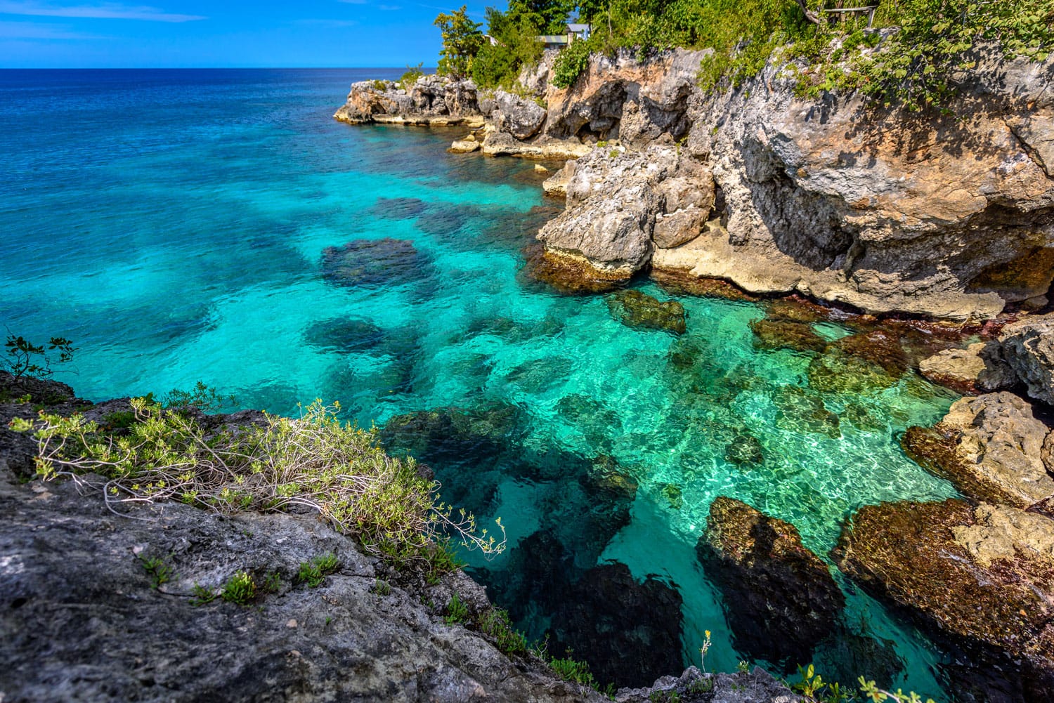 Air pirus jernih yang indah di dekat bebatuan dan tebing di Negril, Jamaika