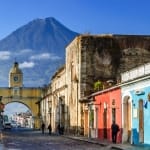 Agua volcano behind Santa Catalina Arch in the colonial town of Antigua, Guatemala