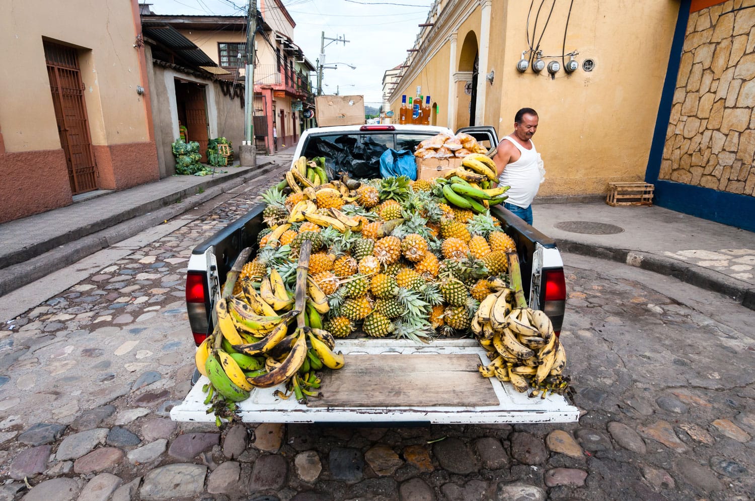 Honduran Farmer presenting his pineapple crops on a local market
