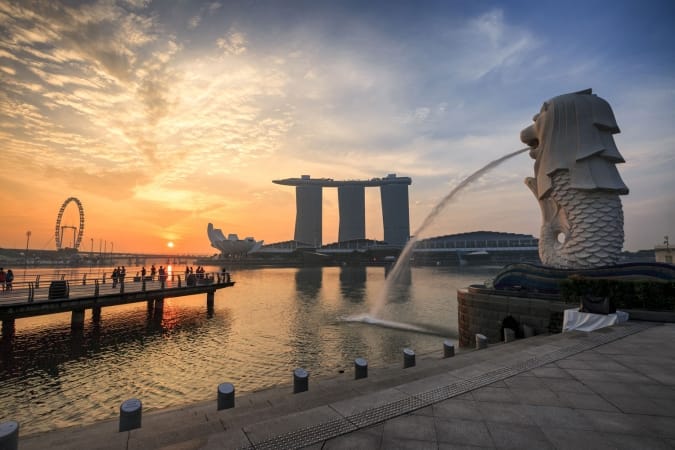 Landscape view of sunrise at Singapore landmark of Merlion and background with Marina Bay Sand building in Singapore