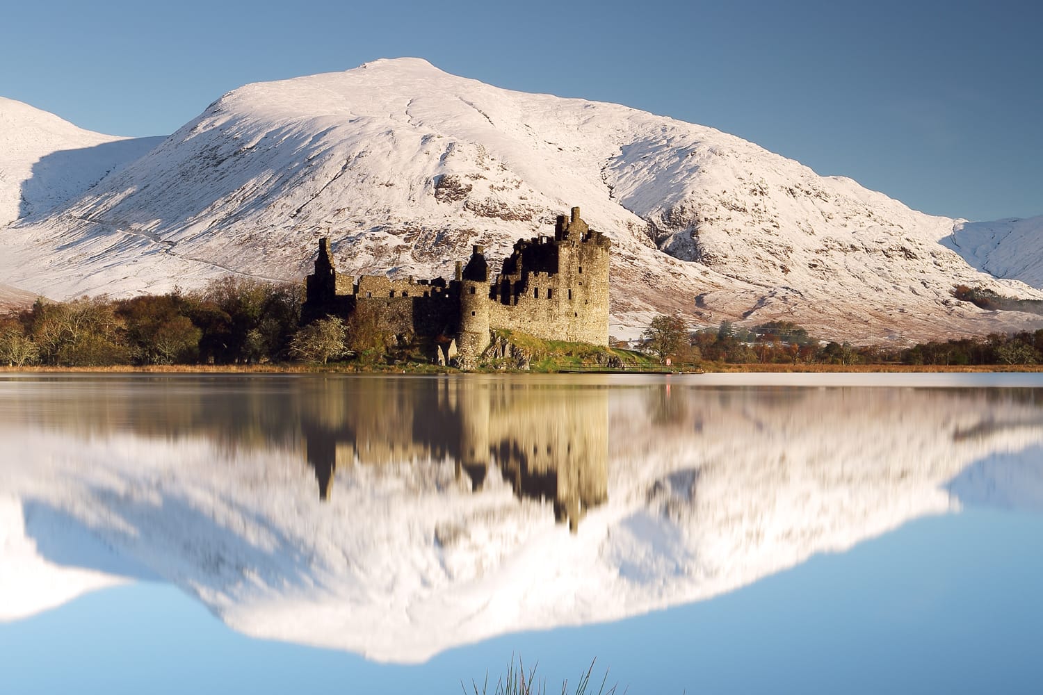 Kilchurn Castle and snow covered mountains reflecting off Loch Awe on a beautiful crisp morning. Dalmally, Scotland.