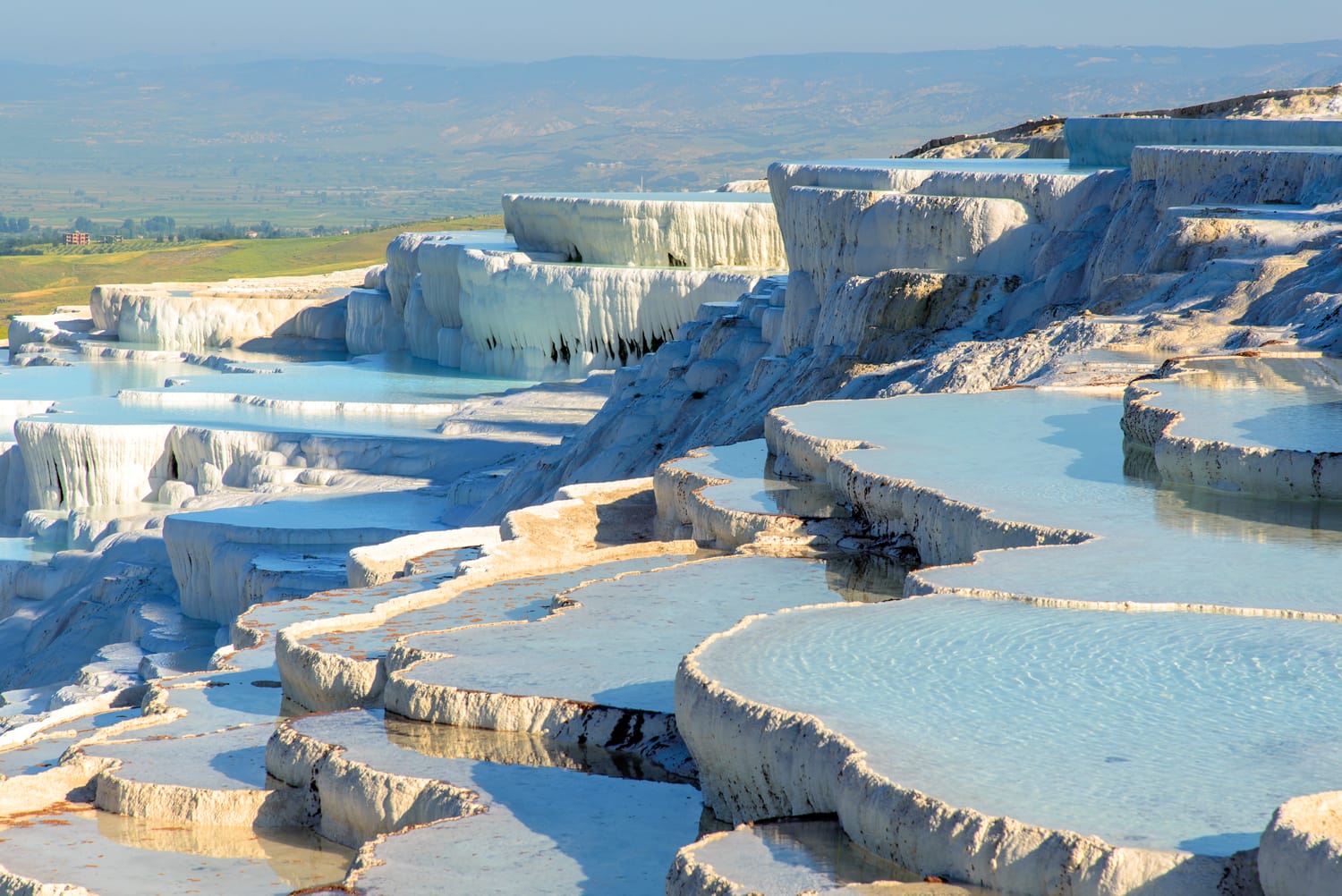 The enchanting pools of Pamukkale in Turkey. Pamukkale contains hot springs and travertines, terraces of carbonate minerals left by the flowing water. The site is a UNESCO World Heritage Site.