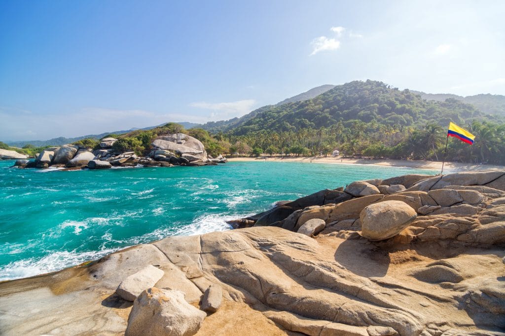 Tropical beach in Tayrona National Park in Colombia with a Colombian flag visible