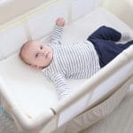 Baby in one of the best travel cribs