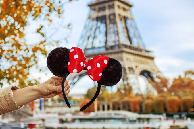 Closeup on Minnie Mouse Ears in female hand on embankment near Eiffel tower in Paris, France
