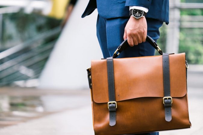 businessman holding leather briefcase