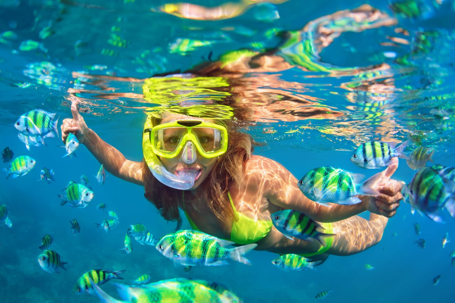 girl in snorkeling mask dive underwater with fishes