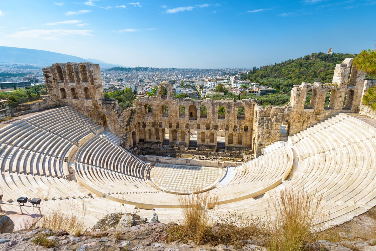 Panoramic view of the Odeon of Herodes Atticus at the Acropolis of Athens, Greece. It is one of the main landmarks of Athens. Scenic panorama of Herod Atticus Odeon overlooking Athens city in summer.