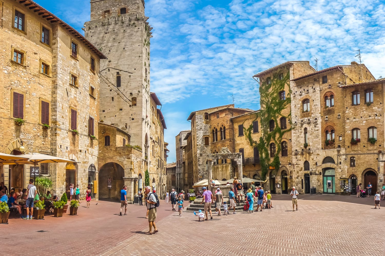 Panoramic view of famous Piazza della Cisterna in the historic town of San Gimignano on a sunny day, Tuscany, Italy
