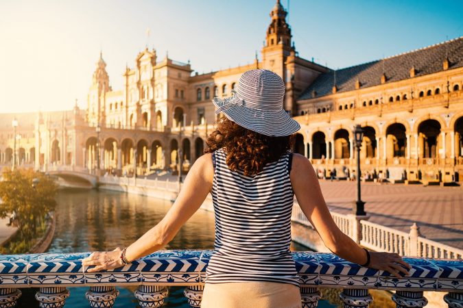 Woman admiring Plaza de Espana (Spain Square). Built on 1928, it is one example of the Regionalism Architecture mixing Renaissance and Moorish styles. Seville, Spain