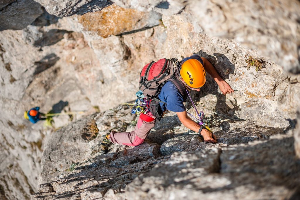 Man wearing helmet climbing rock