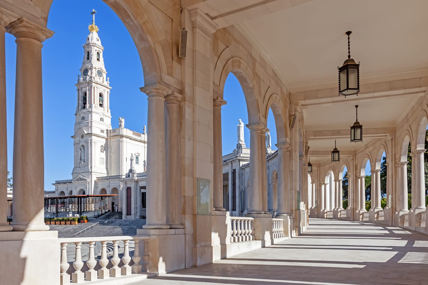 Tempat Suci Fatima, Portugal.  Basilika Bunda Rosario dilihat dari dan melalui barisan tiang.  Salah satu Kuil Maria yang paling penting dan lokasi ziarah bagi umat Katolik