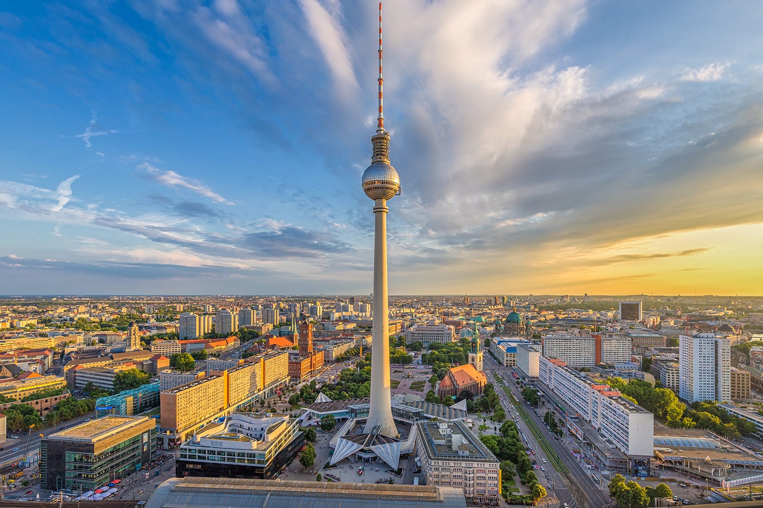 Aerial wide angle view of Berlin skyline with famous TV tower at Alexanderplatz and dramatic clouds in beautiful golden evening light at sunset in summer, Germany