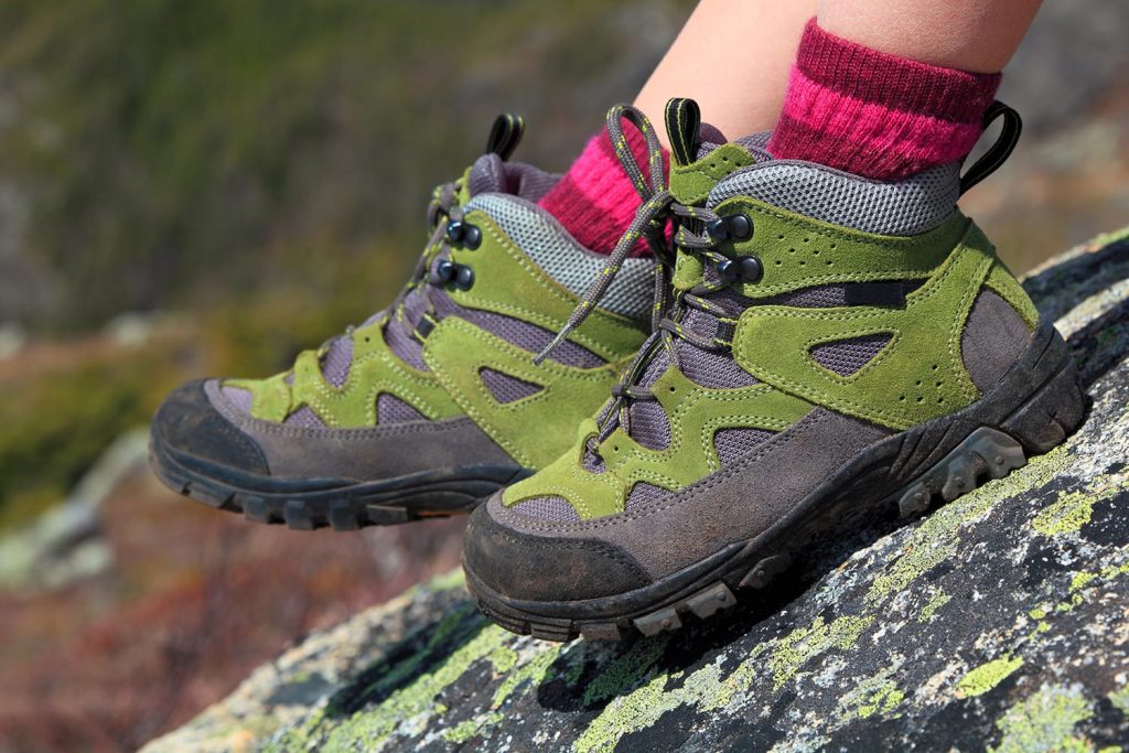 Hiking boots and mountain rocks background