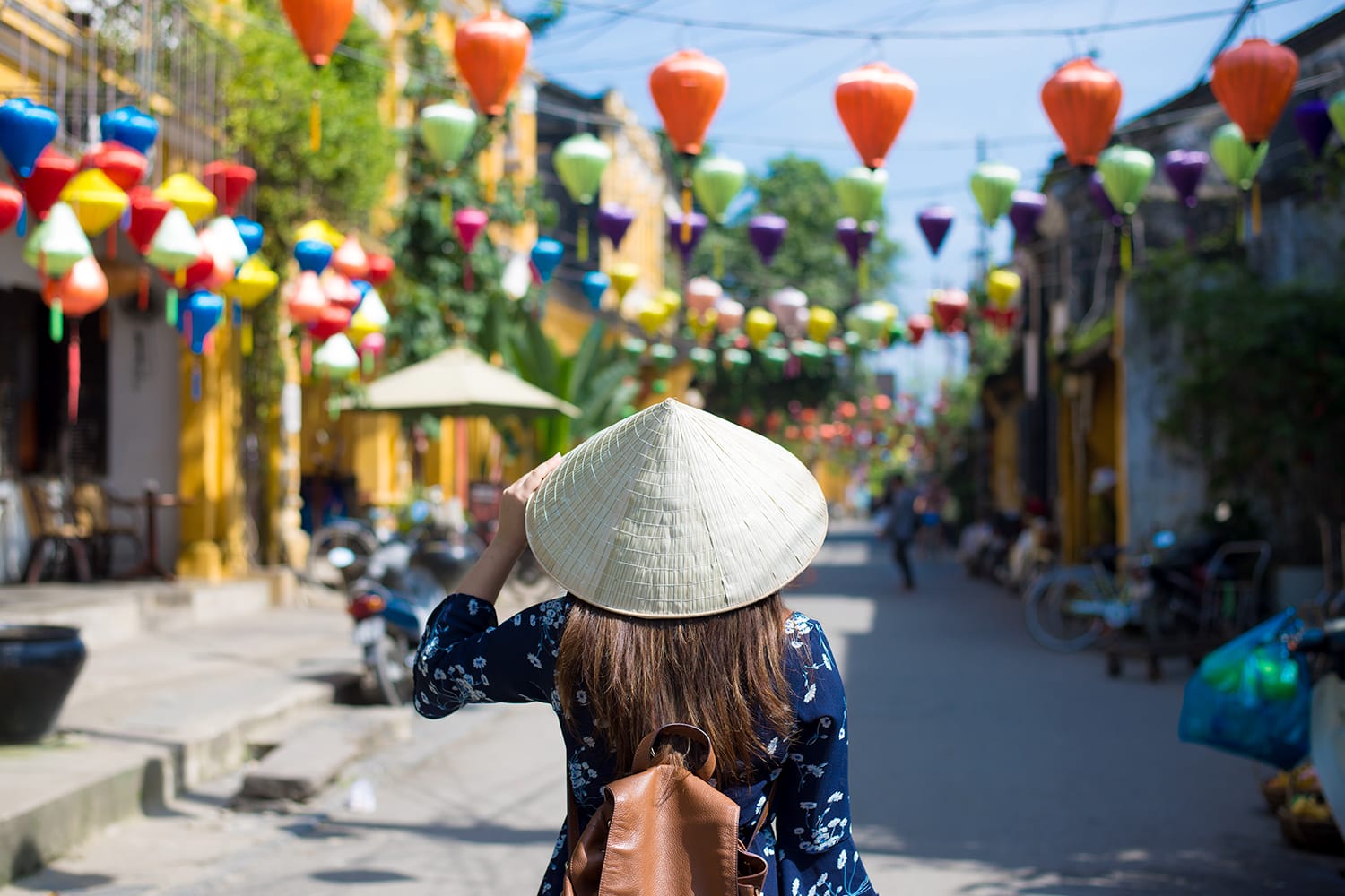 Tourist woman is wearing Non La (Vietnamese tradition hat) and enjoy sightseeing at Heritage village in Hoi An city in Vietnam
