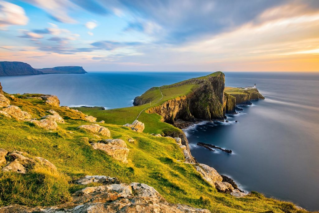 Neist Point Lighthouse on the Isle of Skye bathed in golden light from the setting sun