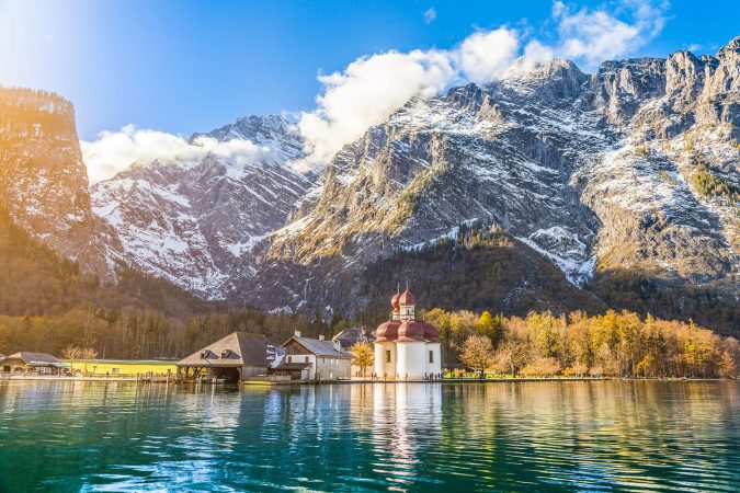 Panoramic view of scenic mountain scenery with Lake Konigssee with famous Sankt Bartholomae pilgrimage church in golden evening light in fall, national park Berchtesgadener Land, Bavaria, Germany