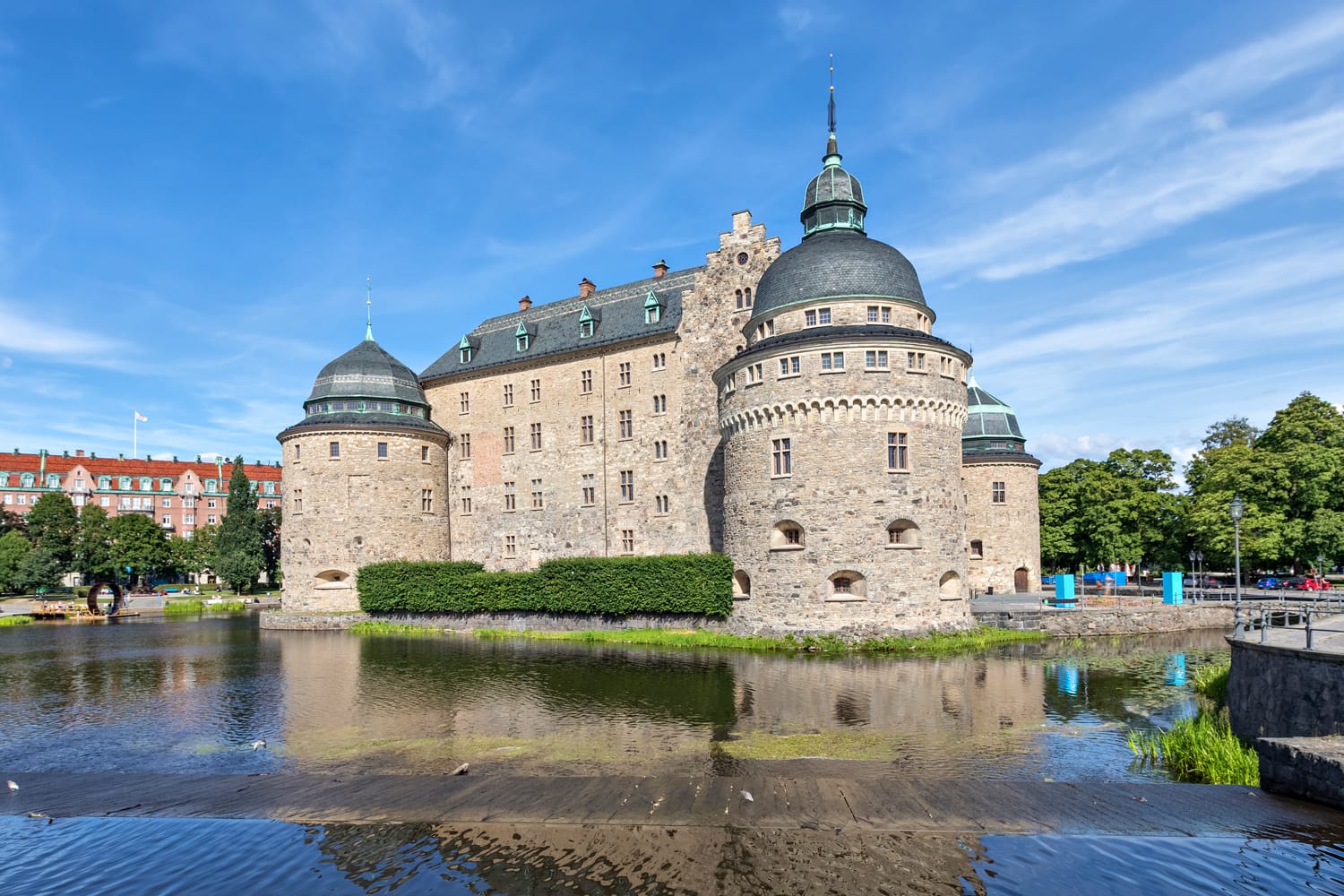 Castell d'Orebro reflectint a l'aigua el dia assolellat d'estiu a la ciutat d'Orebro, Suècia