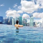 Attractive woman relaxing in Marina Bay Sands infinity swimming pool, Singapore