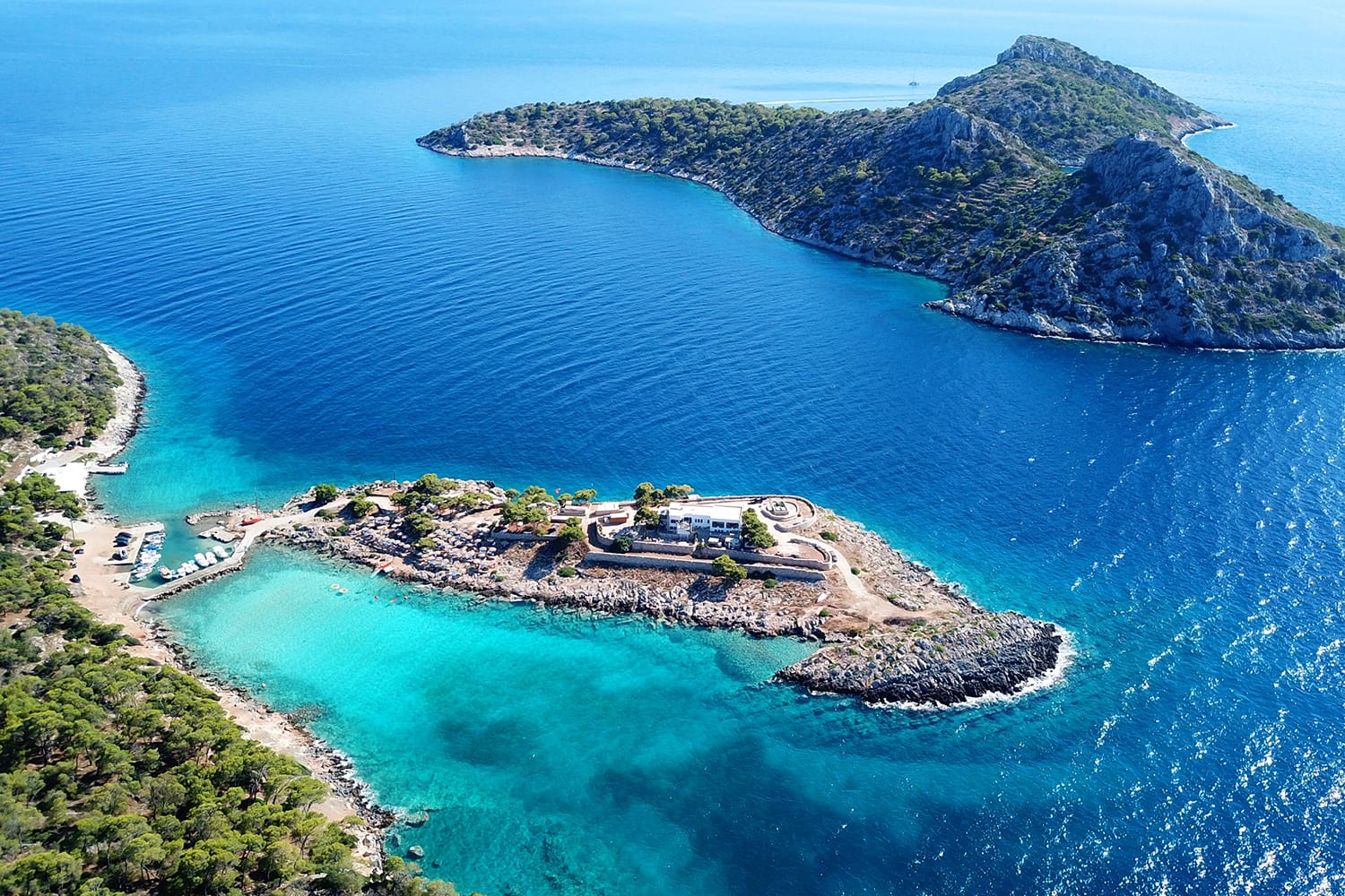 Aerial bird's eye view photo taken by drone of Aponisos beach and lake with clear turquoise waters and pine trees, Agistri island, Saronic gulf, Greece