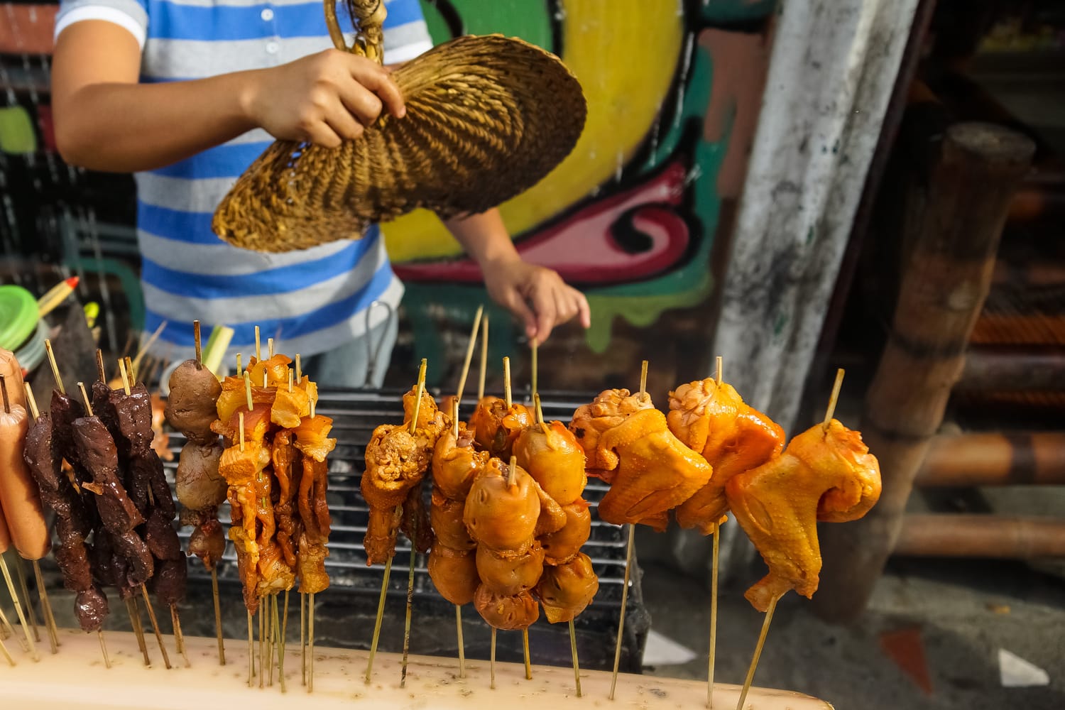 Filipino street food vendor with assortment of kabob meats on sticks