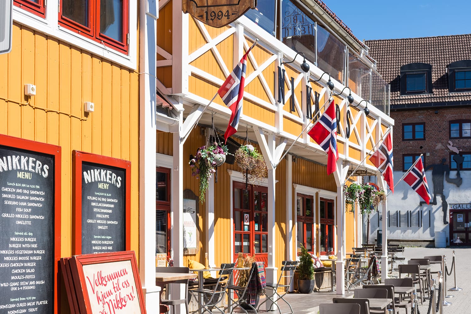 Colorful wooden building with Norwegian flags in Lillehammer, Norway
