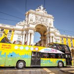 View on the Triumphal arch with tourist bus on the Commerce square during the sunrise in Lisbon city, Portugal