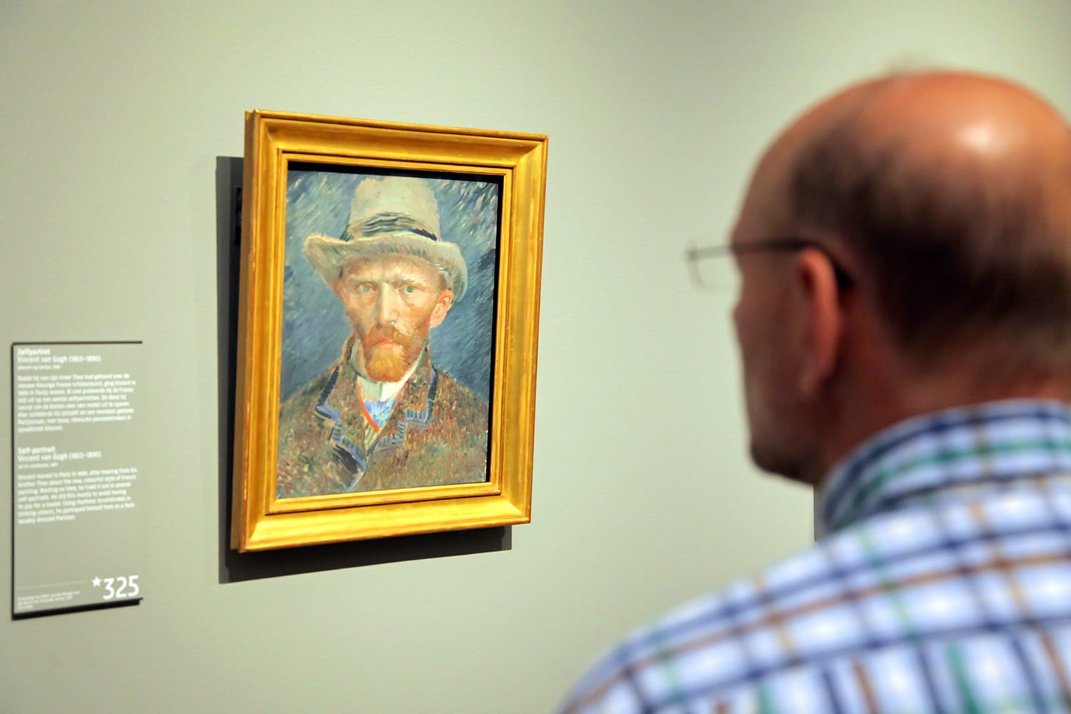 Man looking at Van Gogh self-portrait in Amsterdam, Netherlands