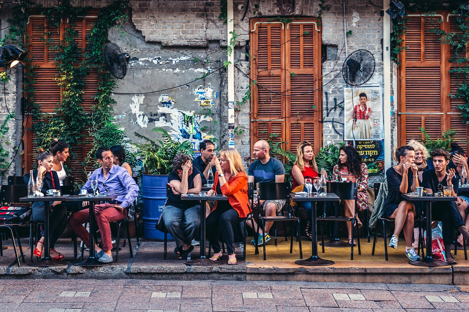 People sits at tables outside the restaurant at Rothschild Boulevard in Tel Aviv, Israel