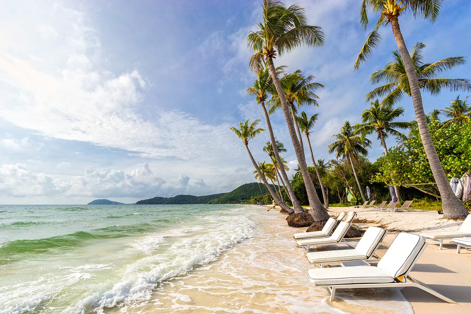 Sunbeds under tropical palms on beautiful Bai Sao beach in Vietnam on Phu Quoc island