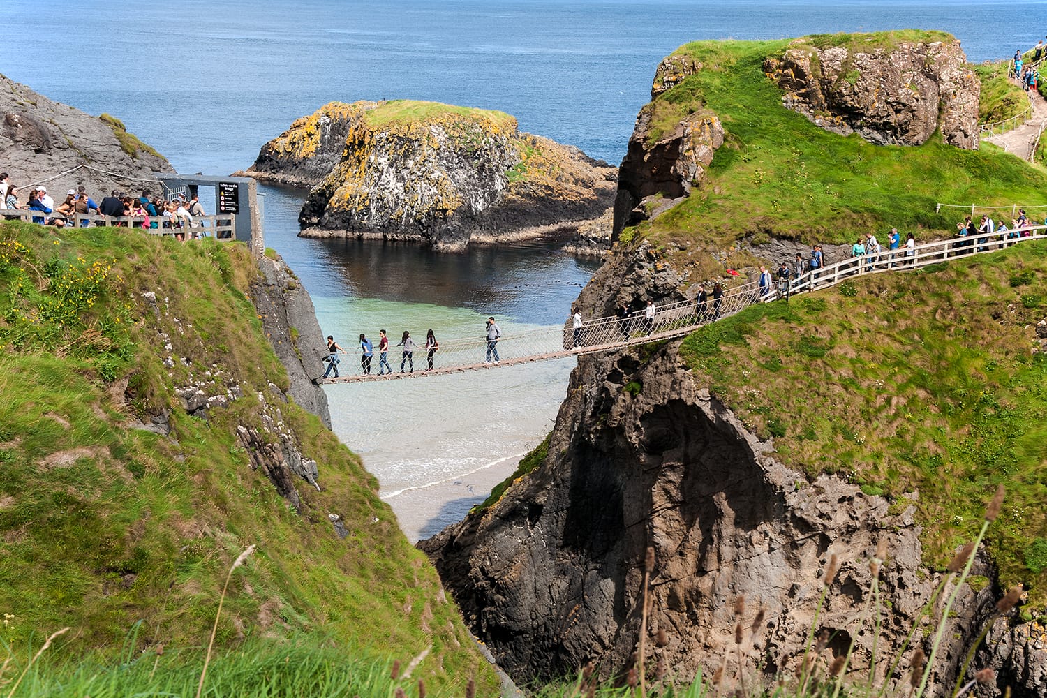 Tourist on the Carrick-a-Rede rope bridge on the Causeway Coast in Antrim County, Northern Ireland