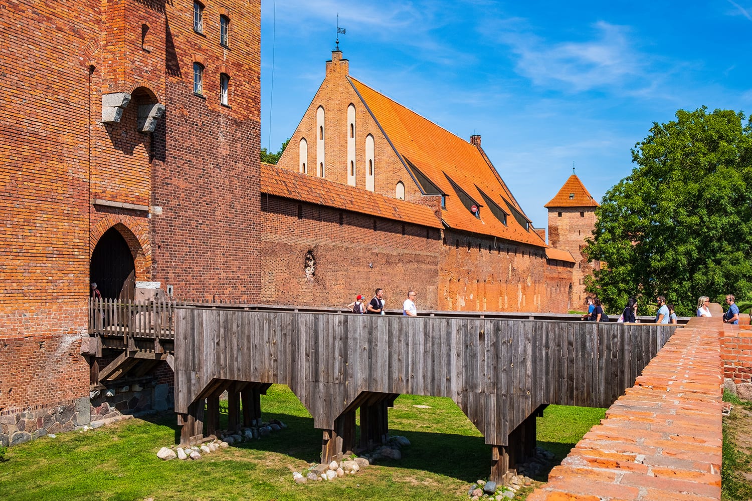 Panoramic view of the medieval Teutonic Order Castle in Malbork, Poland - external defense walls with main gate tower and drawbridge over the moat