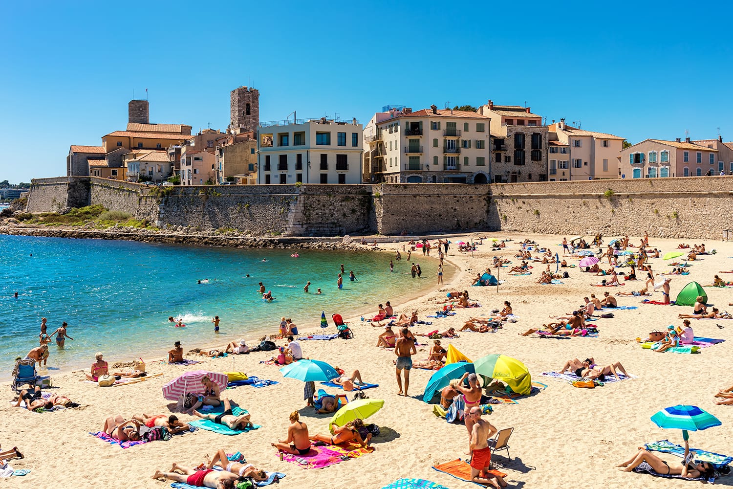 People on Plage de la Gravette - famous and popular sand beach near the Old Town of Antibes, France.