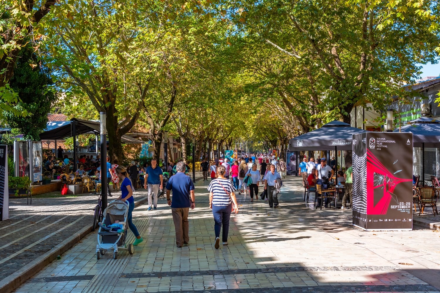 People are strolling on a pedestrian alley in Tirana, Albania
