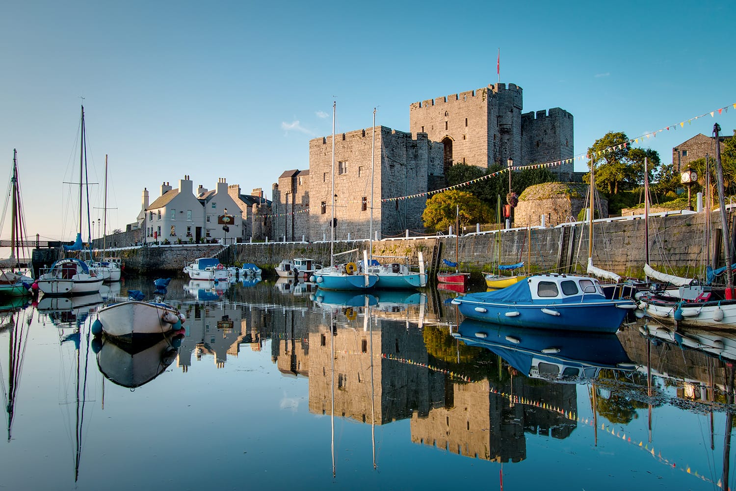 Castle Rushen in Castletown in the Isle of Man, with reflections in the harbor - taken shortly after sunrise