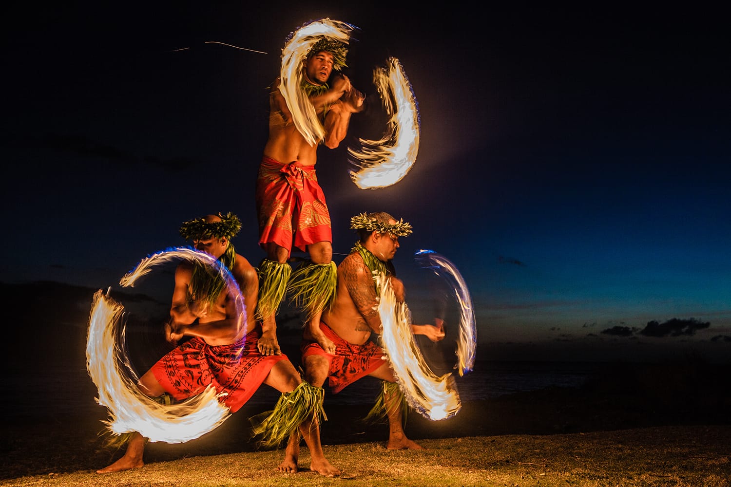 Three fire dancers juggling fire in Hawaii