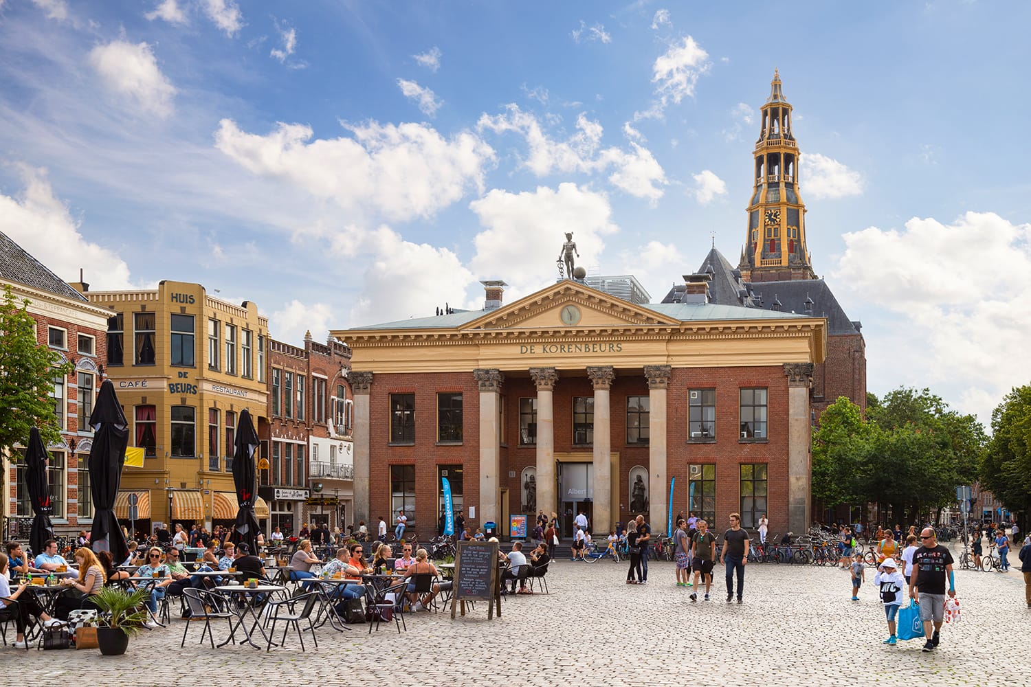 Grain exchange building and church tower on the fish market square in the student city of Groningen.