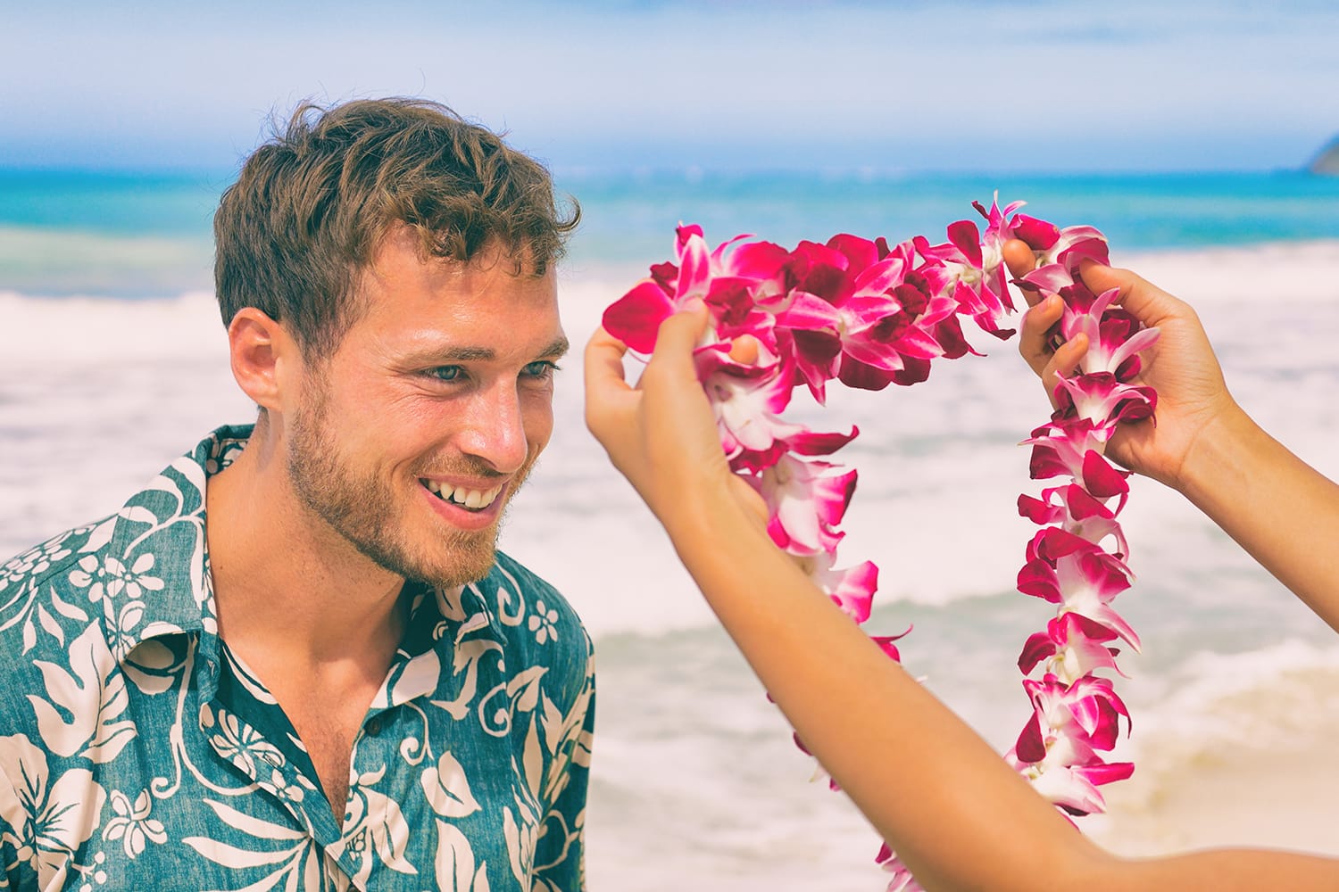 Hawaii woman giving lei flower to welcome a male tourist