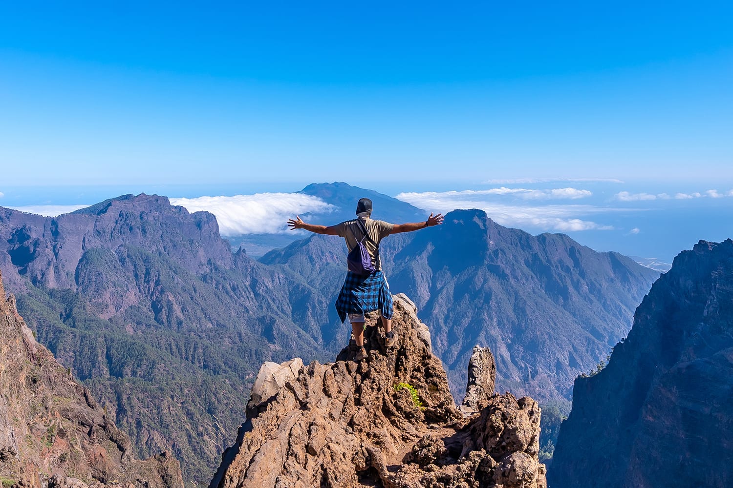 A young man after finishing the trek at the top of the volcano of Caldera de Taburiente near Roque de los Muchachos one summer afternoon, La Palma, Canary Islands. Spain