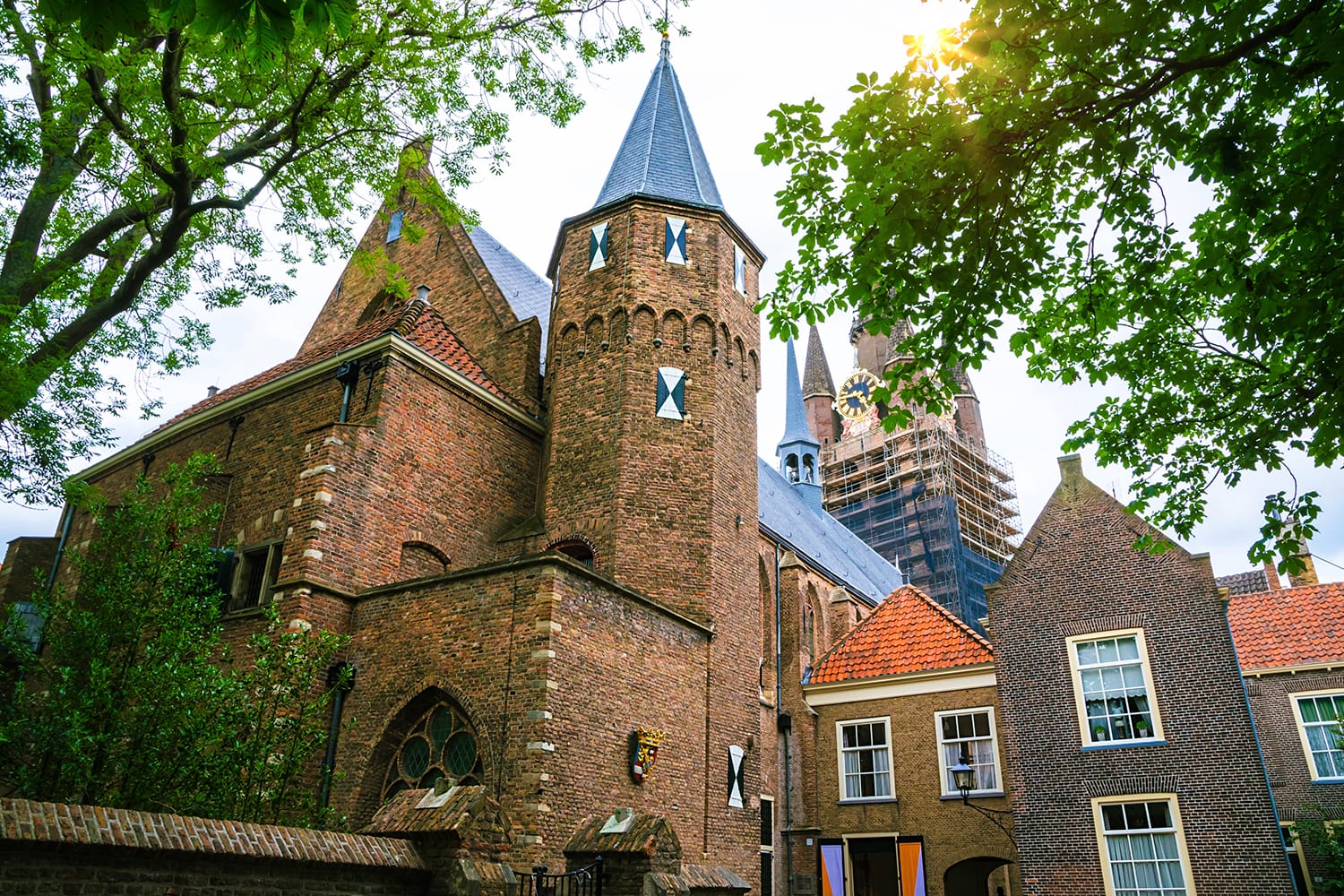 Narrow street and Oude Kerk tower in old beautiful city Delft, Netherlands