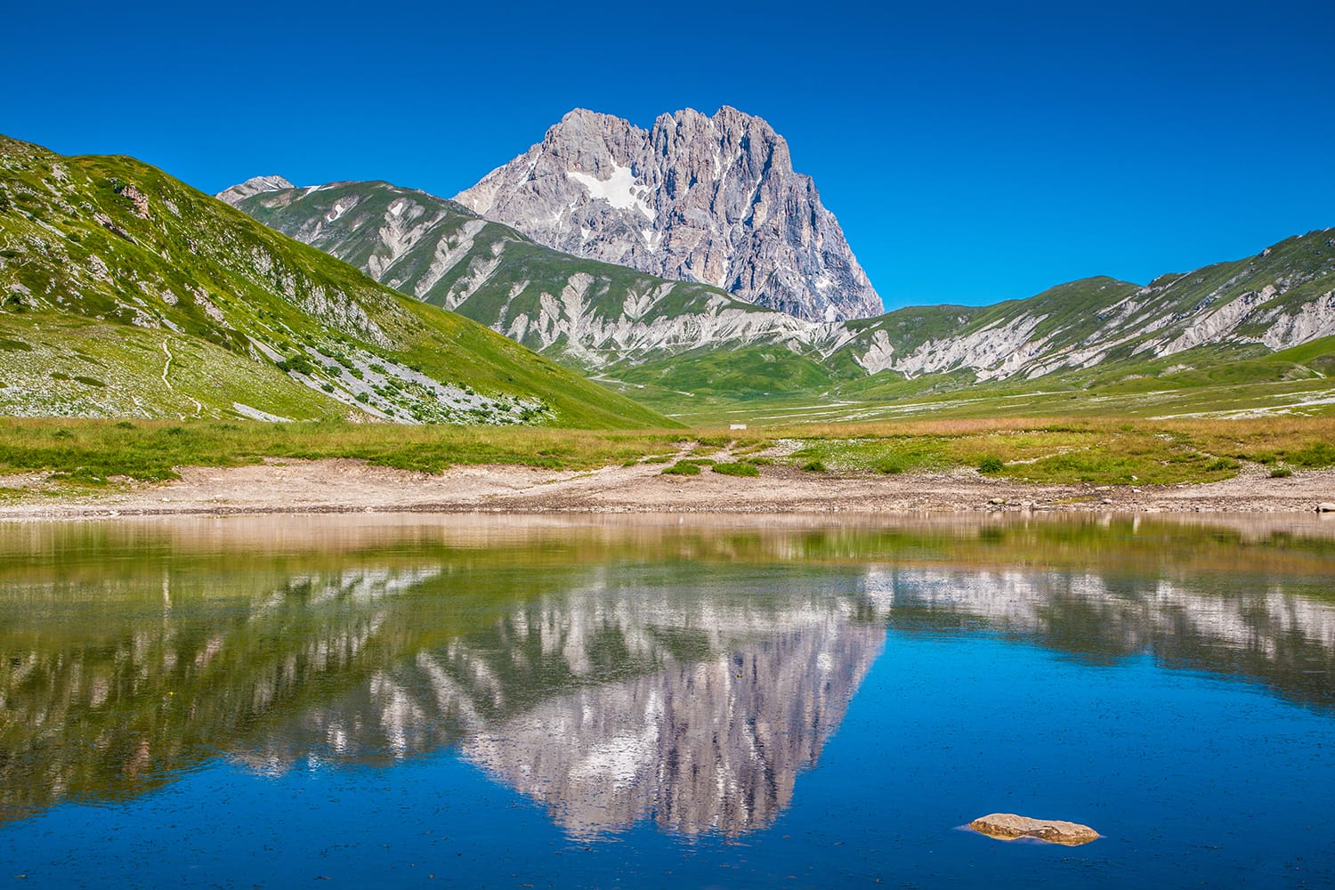 Panoramic view of beautiful landscape with Gran Sasso d'Italia peak at Campo Imperatore plateau in the Apennine Mountains, Abruzzo National Park, Italy
