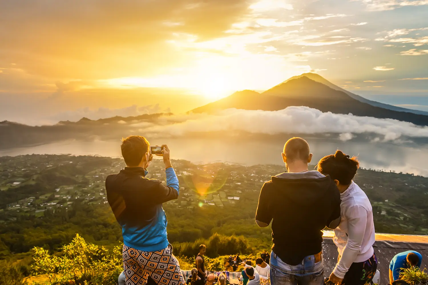 Group of friends watching the sunrise from Mount Batur in Bali