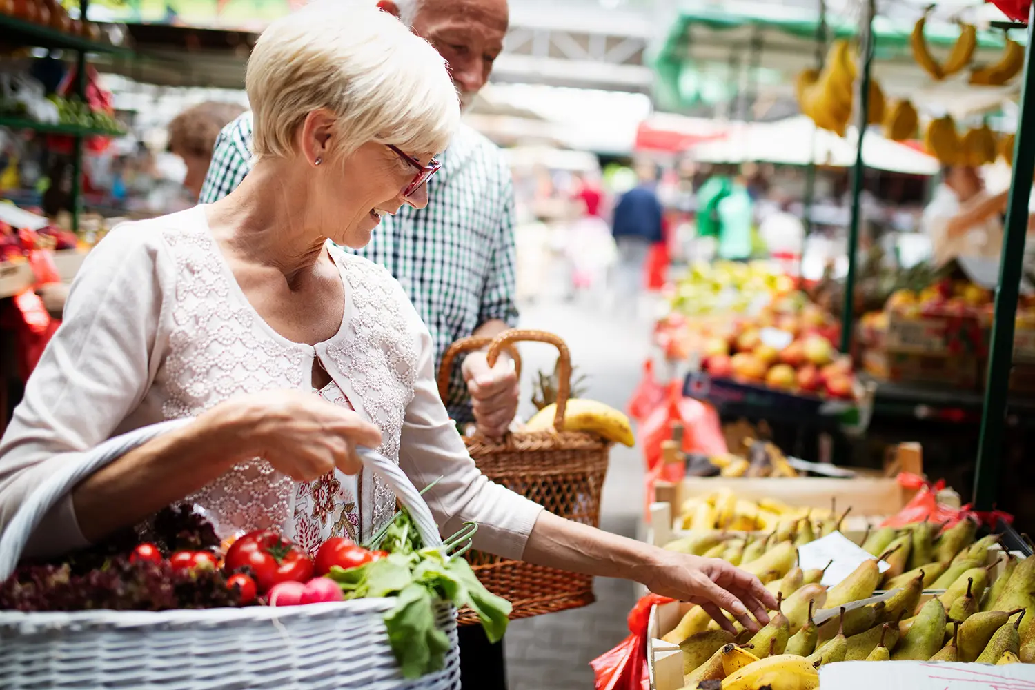Senior women buying vegetables at farmers market