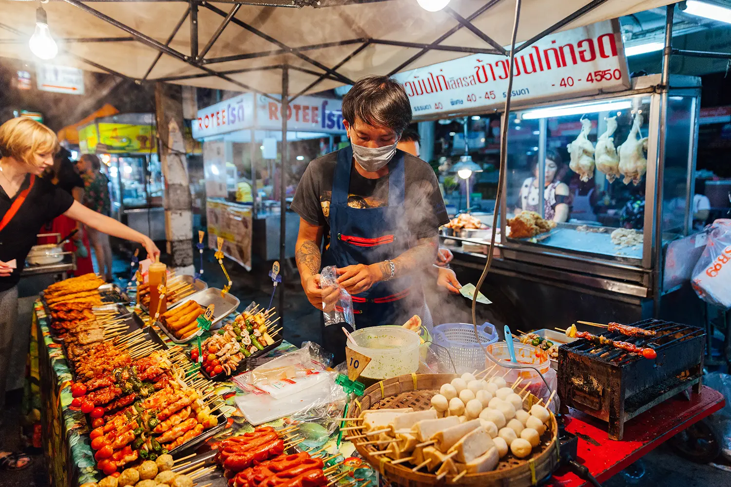 Young man sells satay at the Saturday Night Market in Chiang Mai, Thailand.