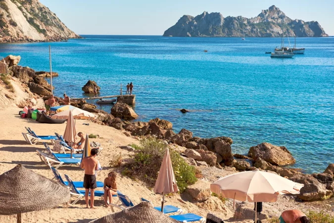 People enjoying the summer at Cala d`Hort beach in Ibiza, Spain