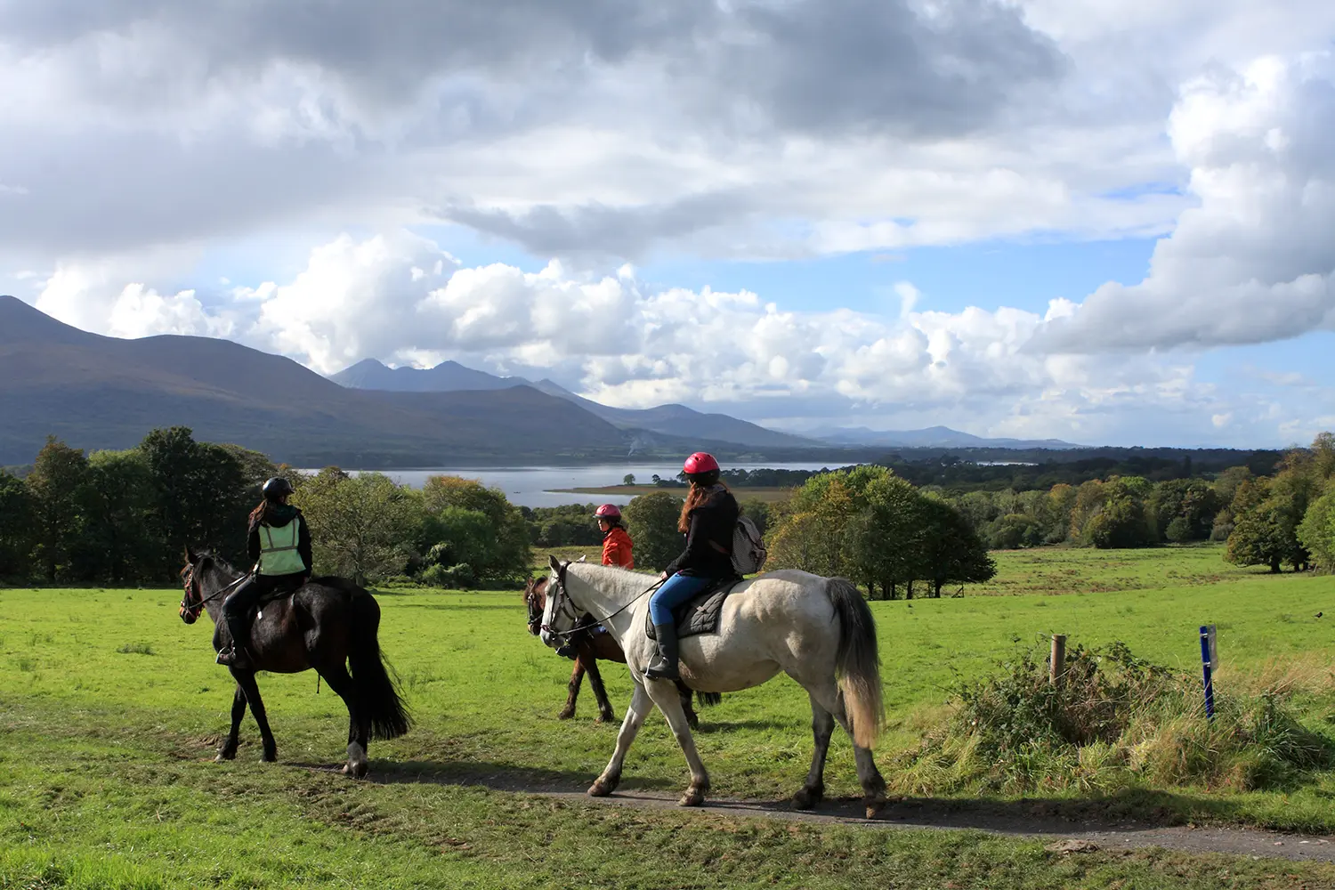 Bright sunshine and cloudy skies greet Horse riders at Killarney National Park. County Kerry, Ireland.