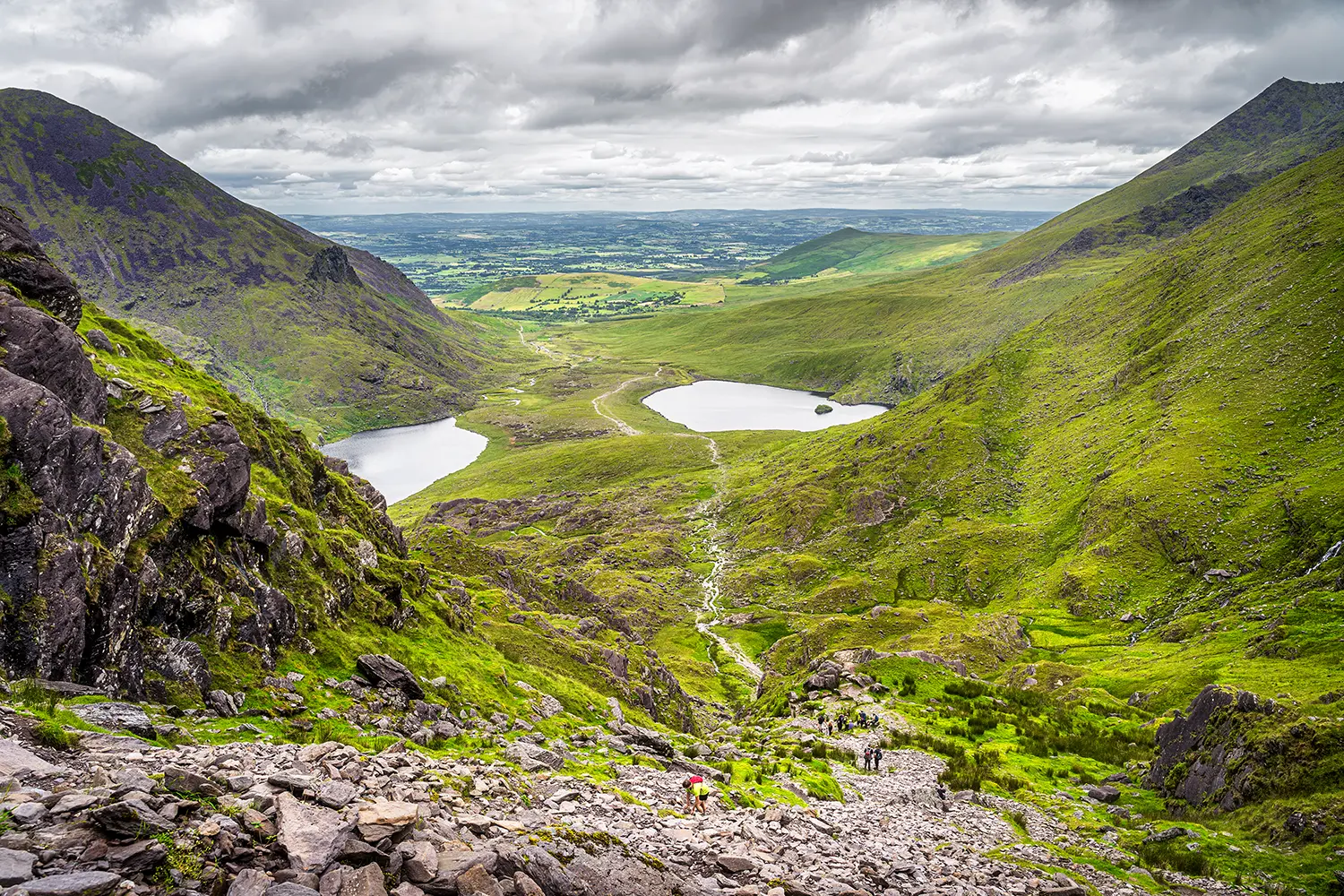 Group of hikers climbing Devils Ladder, one of most difficult trails, to reach highest Irish mountain Carrauntoohil in Ring of Kerry, Ireland