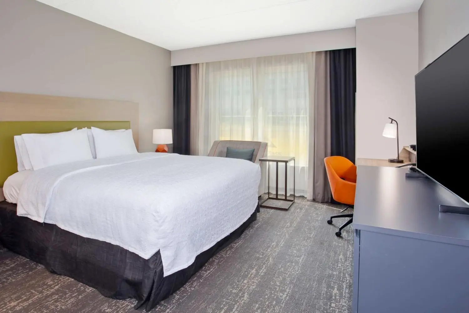 A room with a bed, couch, and table at Hampton Inn & Suites By Hilton- Newark Airport Elizabeth